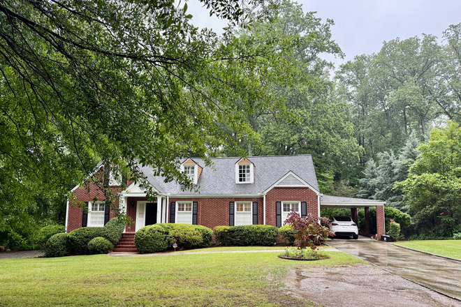 Front of house with long driveway and carport leading to kitchen - LEASE PENDING - Beautiful Druid Hills 4BR 3.5 Bathroom Home Near Emory & CDC – Large Yard, Deck & Pa