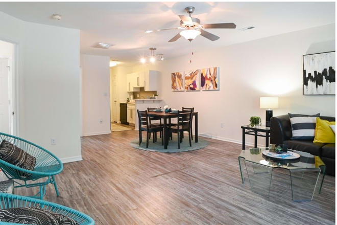 Promotional showroom picture from the front door showing the kitchen and common areas. - University Townhomes at Charlotte