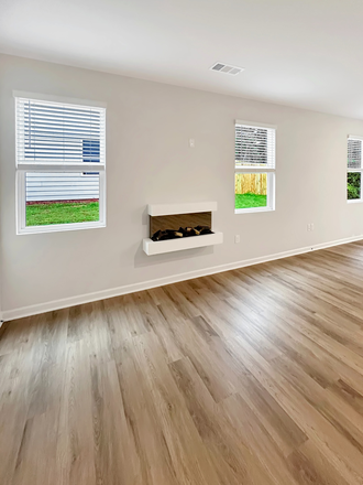 Open concept living room with electric fireplace, hardwood floors, and abundant natural light - Brand New 4BR Townhouse in Mountain Park, Dahlonega
