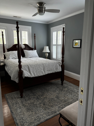 The bedroom includes a queen sized, four poster rice planters bed. There are two bedside tables and lamps. - Spacious Forest Park Two-Room Suite + Private Bath - Walk to Campus (Includes Utilities)