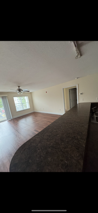 Spacious living room with large windows - Drucker & Falk, LLC Apartments
