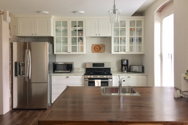 kitchen and custom wood counter island with seating - The Lofts at Odd Fellows