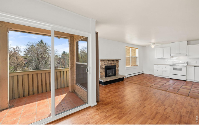 Living room with fireplace opening to balcony and kitchen. - Available Now, 2 Bed, 1 Bath 950 SqFt, Great Location, Unit M39