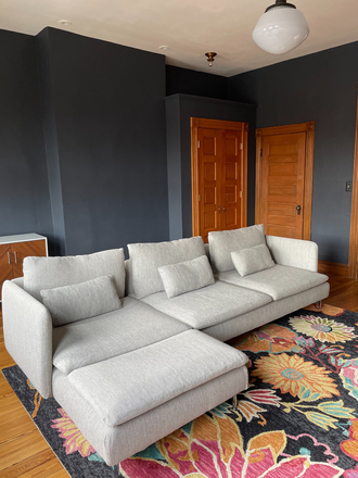 Living room photo 1: large sectional and closet - Furnished apartment in historic row home, including utilities+internet+cleaning (1 b