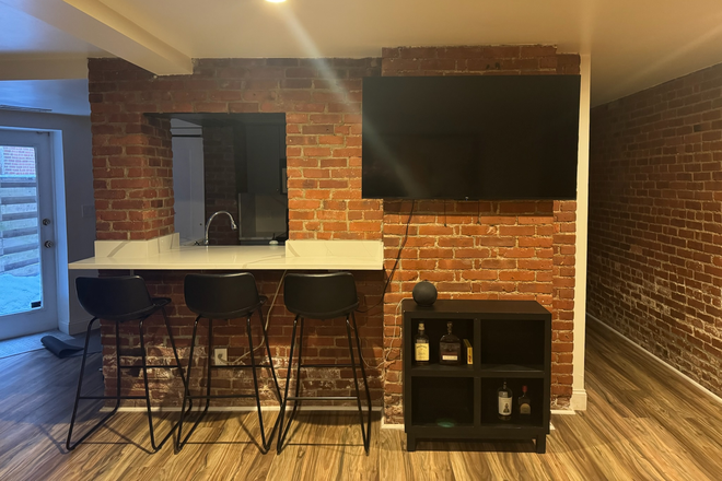 Kitchen bar and TV across from coach. - Newly renovated and furnished apartment, 3min from Campus and Whole Foods, back patio access.