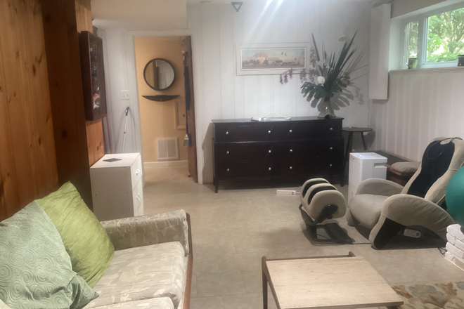 Living room west with massage chair and large dresser. Could be removed if desired. - Bright Basement Apartment in SFH at Glebe, S. 16th, Walter Reed Dr.
