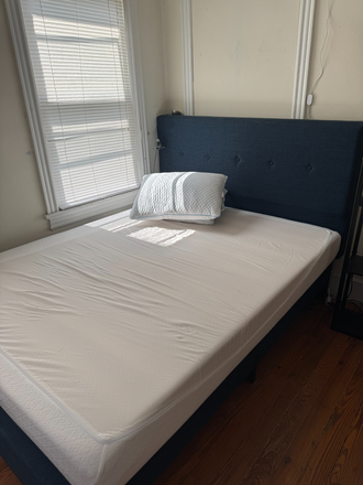 Photo of the bed in the bedroom (which takes up 1/3 of the space). Opposite the bed is long desk and dresser. - Furnished One Bed Room Townhome