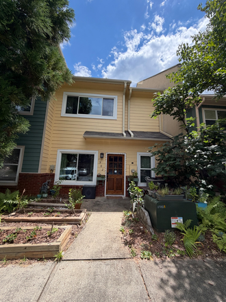 Parking lot side with garden beds featuring emerging blueberries, pomegranates, strawberries, and apples - Bedroom in shared townhouse in beautiful cohousing community
