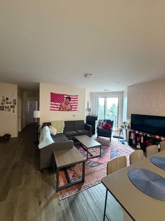 Living room with sliding glass door to porch. - The Province Student Apartments