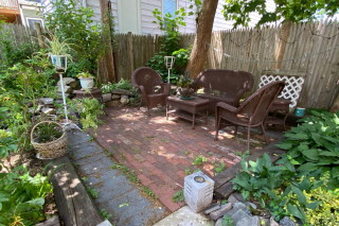 Shaded seating area on brick patio - 3 BR, central AC, one bath duplex Apartments