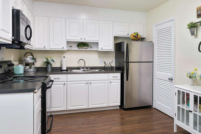 Kitchen with stainless steel appliances - Colonial Townhome Apartments