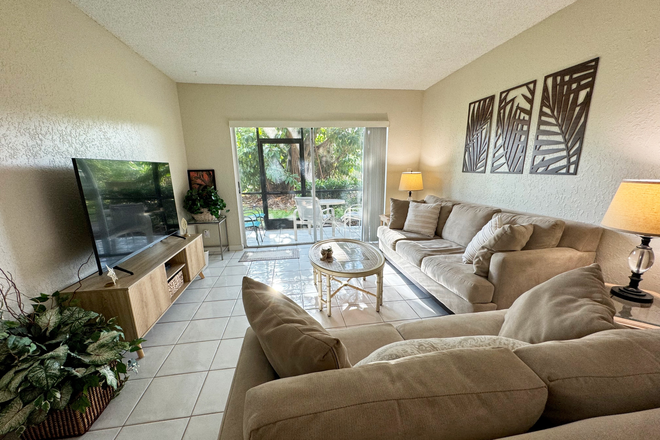 Living Roomm - 5-Min Walk to FAU – Private Room in Furnished 2/2 Condo w/ Pool & Canal Views – $1,700