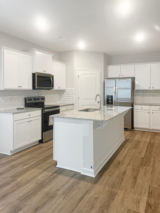 Brand new kitchen with granite island, white cabinets, and all appliances including refrigerator - Brand New 4BR Townhouse in Mountain Park, Dahlonega