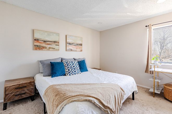 Primary bedroom with king-size bed - Furnished 2BR Condo Near Anschutz Medical Campus