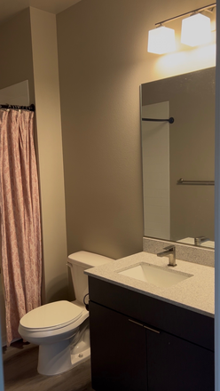Bathroom with shower and bathtub and cabinets underneath sink - The Standard Apartments