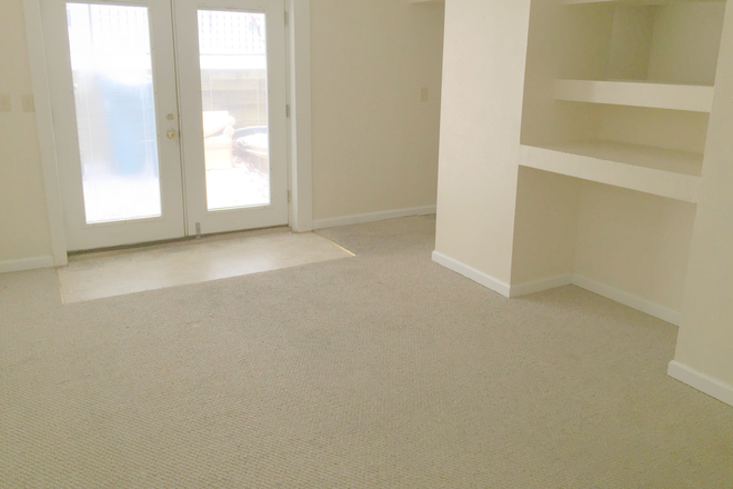 Main living area features large built-in entertainment shelving. - Roomy 1 BR apartment with large bonus room and lots of storage near downtown Edwardsville and