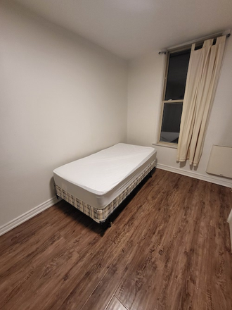 Bed and window - Semi Furnished Studio in The Annex – All Utilities Included