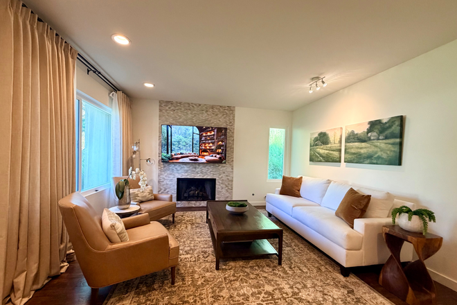 Bright, comfortable living room with cozy seating, fireplace, and smart TV, perfect for relaxing evenings. - Student/Staff- Fully Furnished 3BR Townhome Near Chapman University w/ Utilities and Parking
