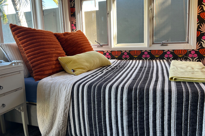 Double bed on platform with lots of windows - Cute ADU Available Apartments