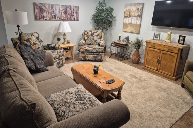 Large living room with plenty of comfortable seating, flat screen TV with Firestick and streaming service included. - Comfortable, fully furnished 1-bedroom apartment with office