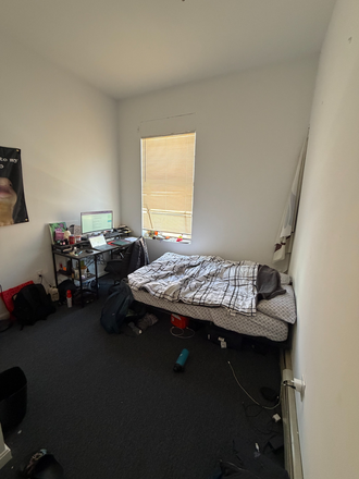 Bedroom, high ceilings, closet on left. Will have bed frame, mattress, and table during sublet time. - Apartment building close to campus