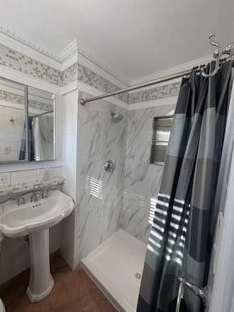 Bathroom view of shower and pedestal sink - 1 Bed 1 Bath Apartment with street parking and large private backyard