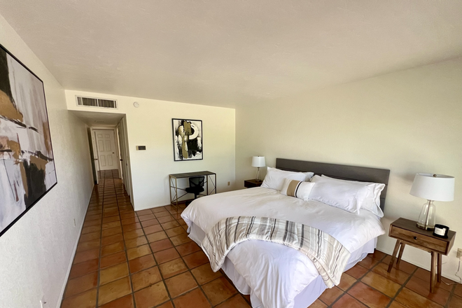 Primary bedroom with King bed, desk, and ensuite bathroom - Furnished 3-BR Tucson home - Mtn Views Near UofA