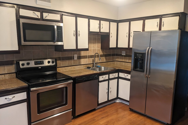 Updated kitchen with stainless steel appliances including microwave, stove, and refrigerator - 3 Bedroom + Bonus room with fenced yard close to campus Townhome