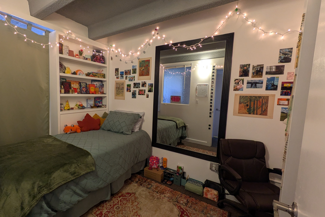 Bedroom. Shelves, dressing mirror, rug, chair. - Sterling Apartments, Close to campus, Fully-furnished bedroom, In unit W/D, Full-size kitchen