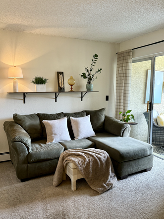 Comfortable couch in main living area leading to balcony. - Stratford West Condos