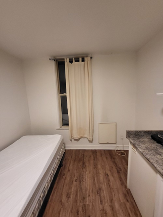 Bed, window, and heater - Semi Furnished Studio in The Annex – All Utilities Included Apartments