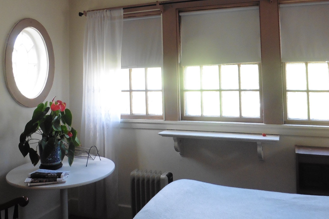 Same view, different furniture; oval window, south. Table, single bed - Large airy studio, walk to to Law School, in Victorian house, private bath, walk-in closet, porch