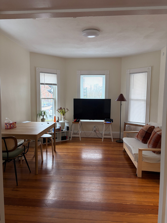 Living room with TV, dining table and sofa (can be extended to queen sized bed) - Spacious 1–2BR Near HBS | Parking Included | Walk to Star Market etc Condo