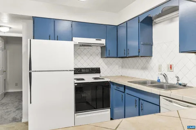 Kitchen includes electric stove, oven, fridge/freezer, dual basin sink, microwave, and ample cabinetry for storage. - 2100 Jefferson Park Ave APT 11