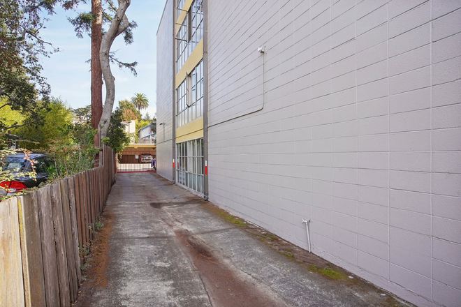 Serene residential street, building windows reflect the clear blue sky - 2627 Hillegass Avenue Apartments