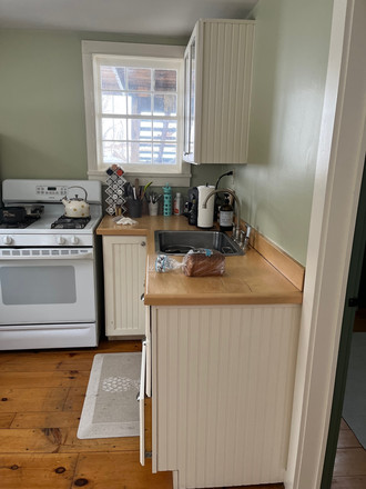 Kitchen has large fridge, gas stove, wood counters, sink with in house filter, cupboard and butcher block. - Maple Vale Farm Cottage Apartments