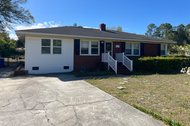 Front entrance with storm door and space for 4 cars in the driveway - Spacious house with four bedrooms and two full bathrooms on Rose Ave, just a short walk to UNCW.