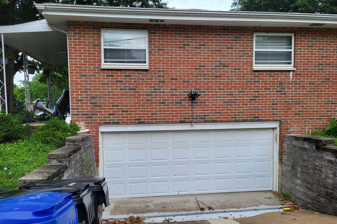 Side of house with garage entrance (items are stored in the garage, but cars are not parked there). - Furnished basement apartment with kitchenette