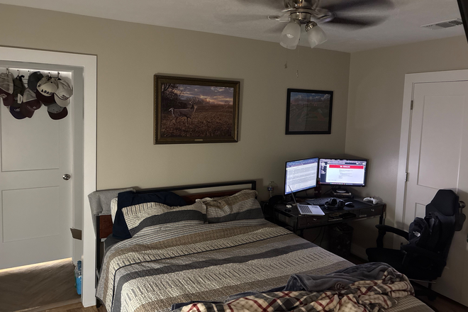 Bedroom with a queen sized bed and a desk - House in Bryan right off Texas Ave