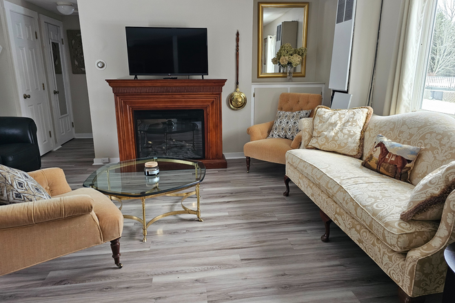 Living room with sliding doors to patio - SAFE Cottage for Rent    5.6 miles from campus Apartments