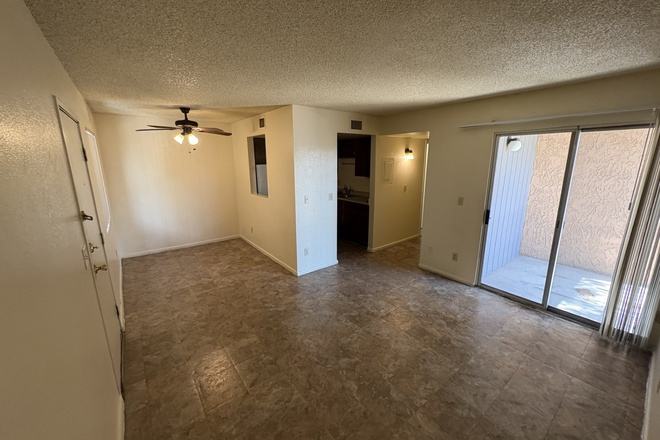Living room and dining area with doors to balcony patio - Quiet and affordable Pepper Tree Apartments