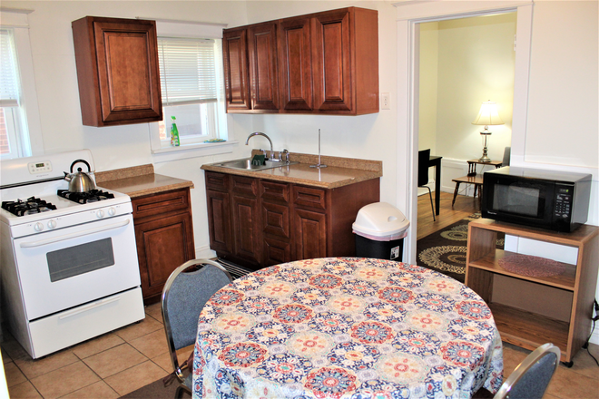 Kitchen with flatware and cookware - Fully Furnished Long and Short Term Housing Apartments