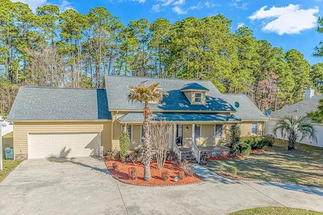 Front of house with circular driveway - House 1 mile from campus backs up to golf course.