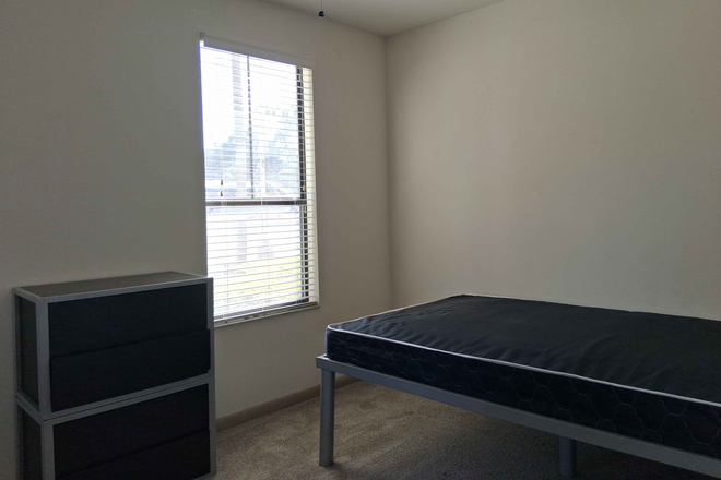 The bedroom's mattress, cabinet, and ceiling fan. - The Lark Central Apartment close to campus