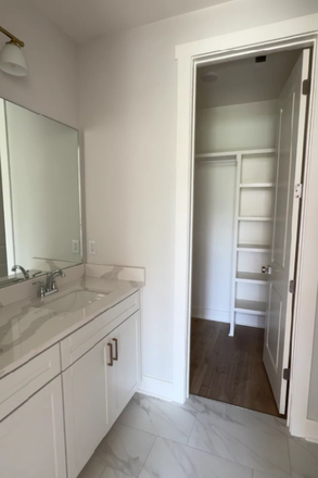Modern bathroom featuring updated tile flooring, sleek vanity, and contemporary fixtures—plus direct access to a spacious walk-in closet. - The Reserve Phase II - 664 Miramar Lane - AVAILABLE AUGUST 1, 2026 Townhome