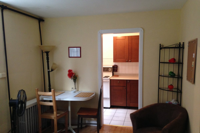 Dining area, kitchen in background, easy chair (shelf unit not included) - Private Bright Furnished Basement Bachelor Apartment