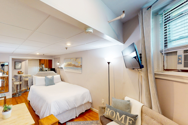 Bed, wall-mounted flat-screen TV - STARS Beacon A Furnished Studio Apartment
