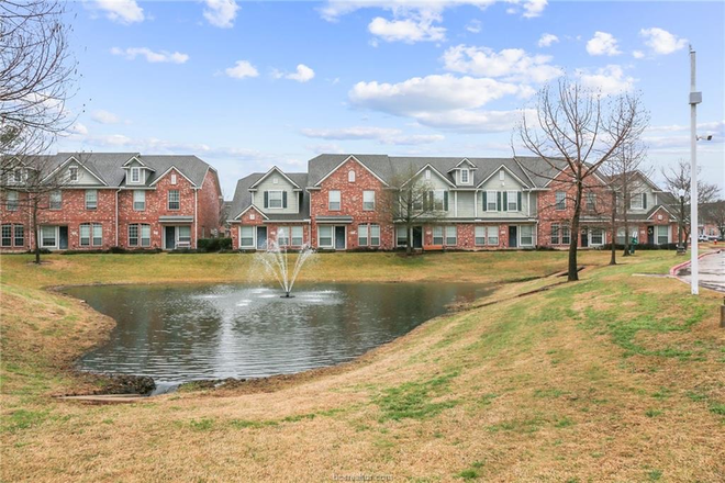 The townhome sits by a serene pond - Bedroom with Private Bath - Gated Townhome