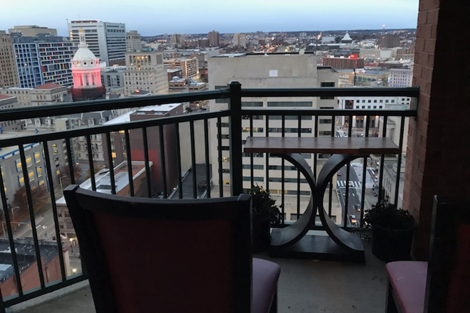 High-floor private balcony featuring sweeping city skyline views. - Prime Downtown Location – Quick 7-Min Drive to UMB
