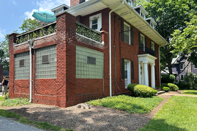 Outside view of deck and green lawns - Bright peaceful one bedroom in verdant Mount Washington, walking distant to historic Preakness track